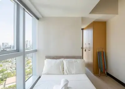 a bedroom with a bed and a large window at Mystay25V-ParksuitesTower1 in Manila