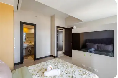 a bedroom with a bed and a bathroom with a sink at Mystay25V-ParksuitesTower1 in Manila