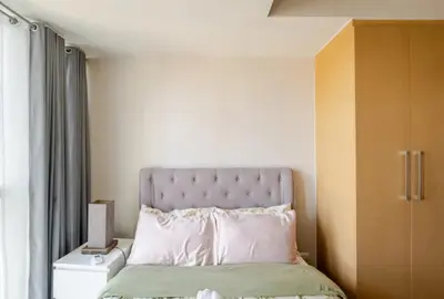 a bed with a pink headboard in a room at Mystay25V-ParksuitesTower1 in Manila