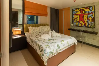 a bedroom with a bed with two swans on it at Premium 1BR suite Modern Filipino at BGC w balcony in Manila