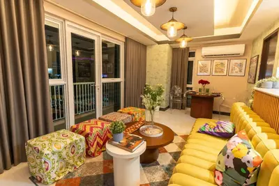 a living room with a yellow couch and a table at Premium 1BR suite Modern Filipino at BGC w balcony in Manila