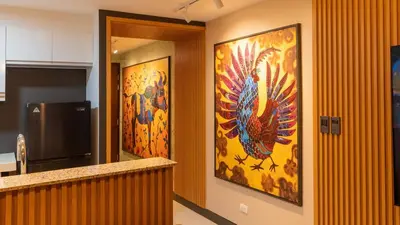 a hallway with three paintings of peacocks on the wall at Premium 1BR suite Modern Filipino at BGC w balcony in Manila