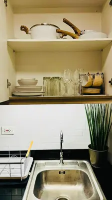 a kitchen sink with plates and dishes on a shelf at MOA Newly Turn Over 1 bedroom with balcony PRIER Place in Manila