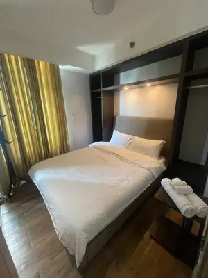 a bedroom with a large bed with white sheets at Makati City Serenity Tower 2501 in Manila