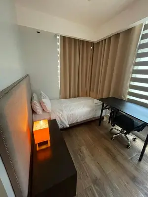 a small room with a bed and a desk and a desk at Makati City Serenity Tower 2501 in Manila