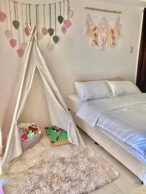 a bedroom with a bed and a basket of toys at Dream Catcher Theme Unit in Manila