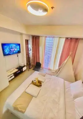 a large white bed in a room with a television at Dream Catcher Theme Unit in Manila