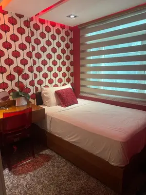 a bedroom with a bed and a window with red walls at 4 Bedroom Luxury Condo in Ortigas in Manila