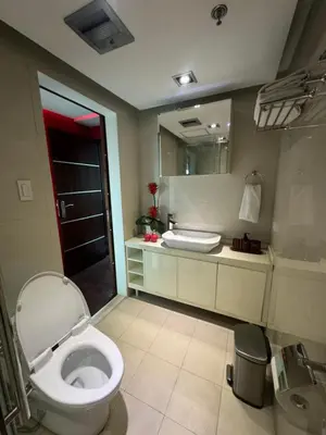 a bathroom with a toilet and a sink and a mirror at 4 Bedroom Luxury Condo in Ortigas in Manila