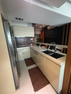 a kitchen with a sink and a stainless steel refrigerator at 4 Bedroom Luxury Condo in Ortigas in Manila