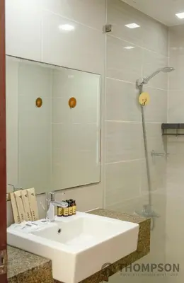 a bathroom with a white sink and a mirror at Premium 2 Bedroom and 1 Living Room Suite with Balcony - One Uptown, BGC in Manila