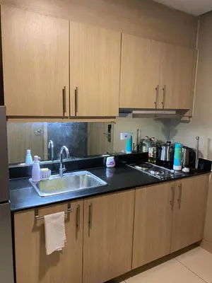 a kitchen with wooden cabinets and a sink at Casa Orana in Manila