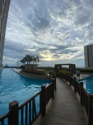 a person walking on a boardwalk next to a swimming pool at Casa Orana in Manila