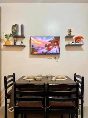 a table with two chairs and a tv on a wall at Casa JYD at Shore Residences - Mall of Asia in Manila