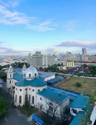 a white building with a blue roof in a city at The Intramuros Suite in Manila