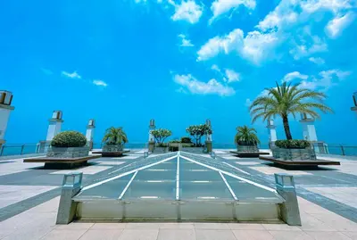 a view of a plaza with palm trees and a blue sky at The Intramuros Suite in Manila