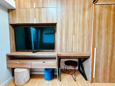 a wooden entertainment center with a tv and a desk at The Intramuros Family Suite in Manila