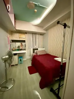a bedroom with a red bed and a desk at Casa Maria in Manila