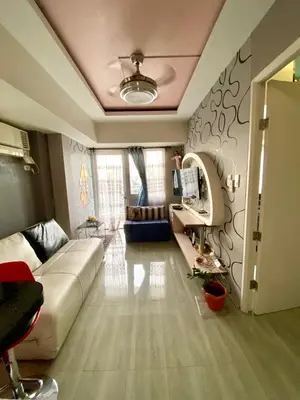 a living room with a white couch and a mirror at Casa Maria in Manila