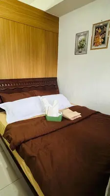 a bedroom with a bed with a wooden headboard at Dawn Haven Staycation in Manila