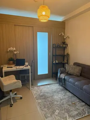 a living room with a couch and a desk with a computer at Near NAIA AIRPORT in Manila