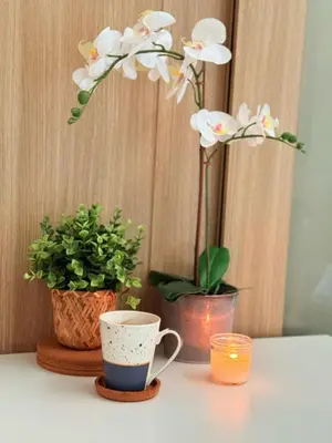 a table with a cup and two vases with flowers at Near NAIA AIRPORT in Manila