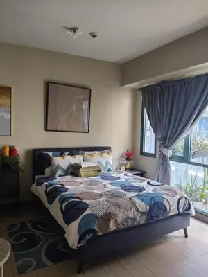 a bedroom with a bed and a window at LDN II Palm Tree Villa NAIA 3 in Manila