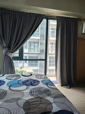 a bedroom with a bed and a large window at LDN II Palm Tree Villa NAIA 3 in Manila