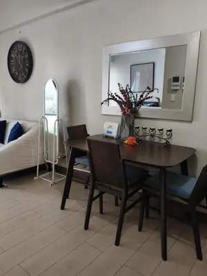 a dining room with a table and a mirror at LDN II Palm Tree Villa NAIA 3 in Manila