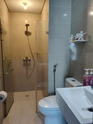 a bathroom with a shower and a toilet and a sink at LDN II Palm Tree Villa NAIA 3 in Manila