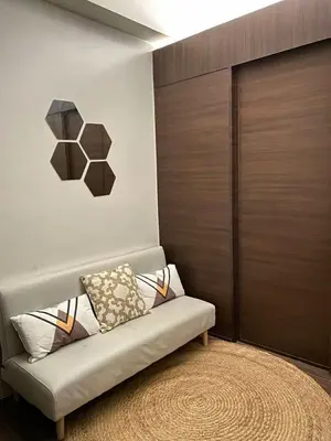 a living room with a couch and a wooden door at Air Residences in Manila
