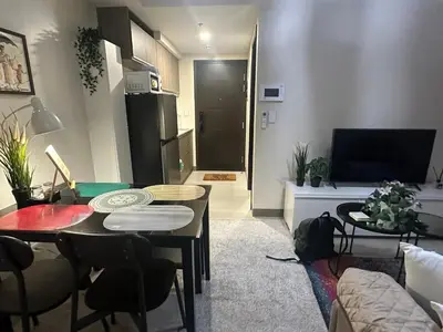 a living room with a table and chairs and a living room at TravelersChoiceCondominium in Manila