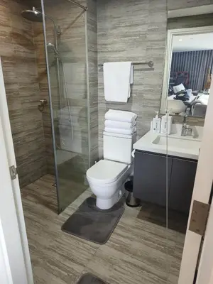a bathroom with a toilet and a shower and a sink at In the City in Manila