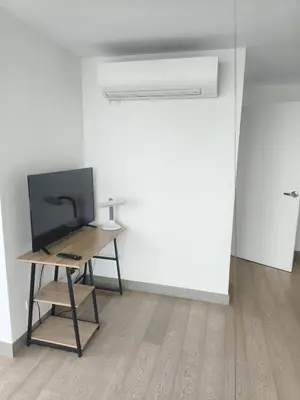 a room with a desk and a television on a table at In the City in Manila
