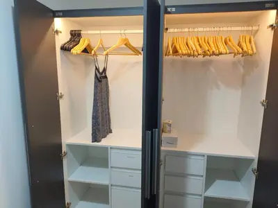 a walk in closet with white cabinets and a black door at In the City in Manila