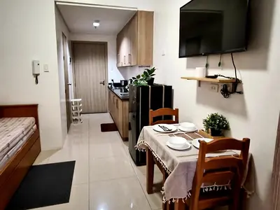 a small kitchen with a table and a dining room at La Vie Riche Holiday Homes - Cozy 1BR Apartment near MOA in Manila
