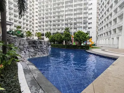 a swimming pool in front of a large building at La Vie Riche Holiday Homes - Cozy 1BR Apartment near MOA in Manila