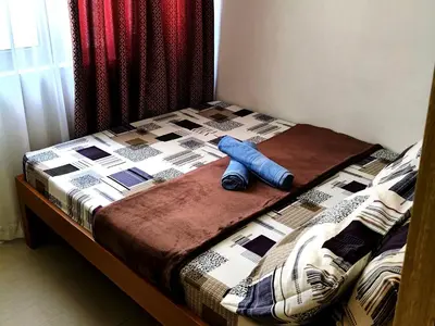a bed with a quilt on top of it at La Vie Riche Holiday Homes - Cozy 1BR Apartment near MOA in Manila