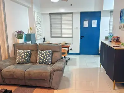 a living room with a couch and a blue door at Torre De Manila in Manila