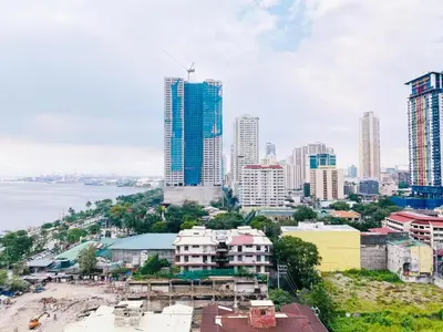 a city skyline with tall buildings and the ocean at Seaview unit in Manila