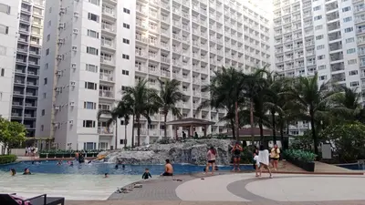 people in a swimming pool in front of tall buildings at Blytheo Urban Staycation by Jonathan in Manila
