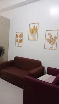 a living room with a couch and pictures on the wall at Blytheo Urban Staycation by Jonathan in Manila