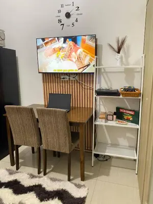 a dining room table with chairs and a laptop on it at Blytheo Urban Staycation by Jonathan in Manila