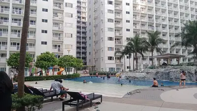 a swimming pool in a large building with people in it at Blytheo Urban Staycation by Jonathan in Manila