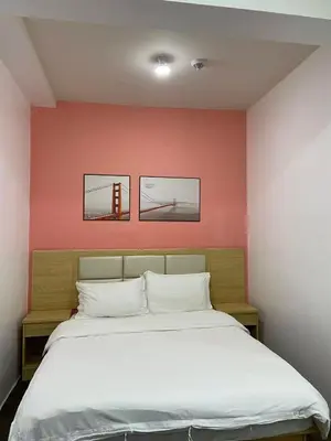 a bedroom with a bed with two pictures on the wall at FX Property 3950 in Manila