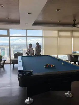two people standing in a room with a pool table at FX Property 3950 in Manila