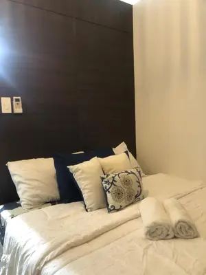 a large bed with a black headboard and white pillows at Comfortable & Peaceful for You #4806 in Manila