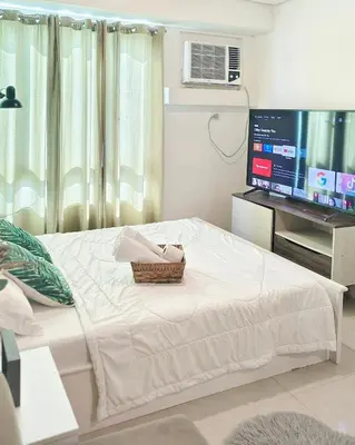 a bedroom with a bed and a flat screen tv at The Beacon Makati by Christine Suites PH in Manila