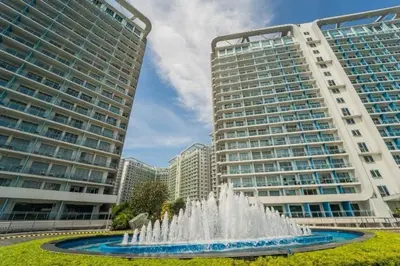 a fountain in front of two tall buildings at Apple Paris Azure Staycation in Manila
