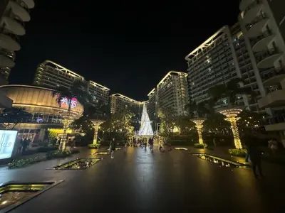 a city at night with a christmas tree and buildings at Apple Paris Azure Staycation in Manila